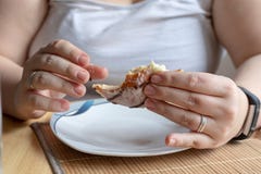 Close up of a young woman holding a delicious doughnut with chocolate and vanille and biting from him stock photo Close up of a young woman holding a delicious doughnut with chocolate and vanille and biting from him stock photo