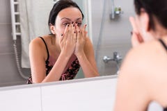 Close up young woman washing face standing in front of mirror stock images Close up young woman washing face standing in front of mirror stock images