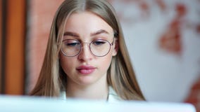 Close-upgezicht van mooie bezige jonge bedrijfsvrouw die glazen dragen die het scherm van laptop bekijken stock video Close-upgezicht van mooie bezige jonge bedrijfsvrouw die glazen dragen die het scherm van laptop bekijken stock video