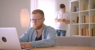 Close-upportret van twee bezige Kaukasische zakenlieden die in de bibliotheek samenwerken Men typt op laptop terwijl stock video Close-upportret van twee bezige Kaukasische zakenlieden die in de bibliotheek samenwerken Men typt op laptop terwijl stock video
