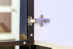 Closeup of an adjustable concealed hinge fixed on a cabinet with a glass door stock photos Closeup of an adjustable concealed hinge fixed on a cabinet with a glass door stock photos