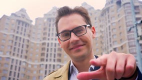 Closeup of attractive confident man pointing on the camera on the background of high buildings. You can do it message stock video Closeup of attractive confident man pointing on the camera on the background of high buildings. You can do it message stock video
