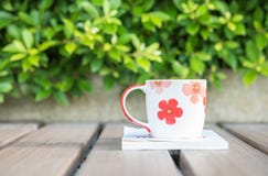Closeup Beautiful Cup Of Coffee On White Book On Blurred Wooden Table And Green Plant In The Garden Textured Background Stock Photo