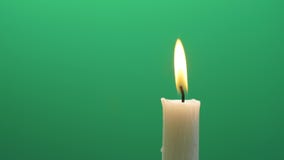 Closeup candle flame igniting and burning on chroma key green screen background