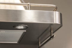 Closeup of details of buttons on a metal exhaust fan with light in a luxury kitchen. royalty free stock photo Closeup of details of buttons on a metal exhaust fan with light in a luxury kitchen. royalty free stock photo