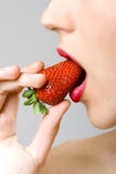 Closeup of female face biting a strawberry stock photos Closeup of female face biting a strawberry stock photos