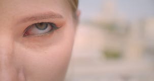 Closeup half face portrait of young caucasian female face rolling her eyes being annoyed looking at camera outdoors stock video Closeup half face portrait of young caucasian female face rolling her eyes being annoyed looking at camera outdoors stock video