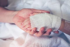 Close up hand of parent holding hand of child in hospital. Retro Royalty Free Stock Images Close up hand of parent holding hand of child in hospital. Retro Royalty Free Stock Images