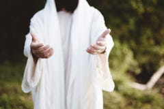 Closeup of Jesus Christ reaching out with a blurred background