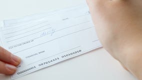 CLoseup 4k footage of young woman filling 100 dollar bank cheque for charity purposes stock video CLoseup 4k footage of young woman filling 100 dollar bank cheque for charity purposes stock video
