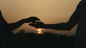 Closeup of man and woman holding hands gently. Couple enjoying romantic date