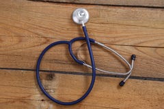 Closeup of a medical stethoscope, isolated on wooden background stock photos Closeup of a medical stethoscope, isolated on wooden background stock photos
