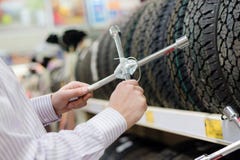 Closeup On Hands Holding Spanner Or Cross Wrench Looking At Automobiles Tire Wheels At The Shopping Store In The Supermarket Stock Images Closeup On Hands Holding Spanner Or Cross Wrench Looking At Automobiles Tire Wheels At The Shopping Store In The Supermarket Stock Images