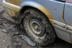 Grey van has its tires full of clay from driving on a wet clay road - 1/2 stock images Grey van has its tires full of clay from driving on a wet clay road - 1/2 stock images