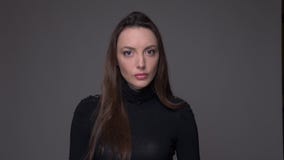Closeup portrait of adult attractive caucasian female with brunette hair looking at camera with background isolated on stock video footage Closeup portrait of adult attractive caucasian female with brunette hair looking at camera with background isolated on stock video footage