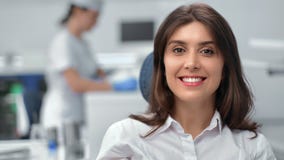 Closeup portrait brunette woman dentistry patient sitting on chair white toothy smile at clinic