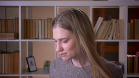 Closeup portrait of young attractive female student dancing with joy in the college library indoors stock video footage Closeup portrait of young attractive female student dancing with joy in the college library indoors stock video footage