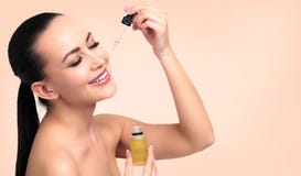 Closeup shot of cosmetic oil applying on young woman`s face stock photography Closeup shot of cosmetic oil applying on young woman`s face stock photography