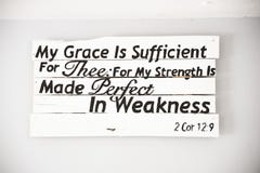 Closeup shot of a white wooden sign with a bible quote and a white background