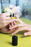 Closeup shot of a woman in a nail salon receiving a manicure by a beautician with nail file. Woman getting nail manicure. Beautici royalty free stock photography Closeup shot of a woman in a nail salon receiving a manicure by a beautician with nail file. Woman getting nail manicure. Beautici royalty free stock photography