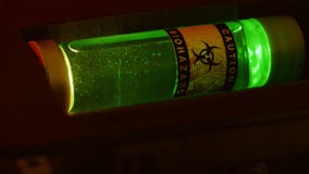 closeup-tech-looking-biohazard-sample-large-vial-green-luminescent-liquid-42912493.jpg