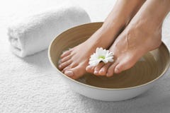 Closeup View Of Woman Soaking Her Feet In Dish With Water And Flower On White Towel Stock Images