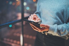 Closeup view of woman holding modern mobile phone in hands.Girl pointing fingers on empty touch mobile screen at night royalty free stock images Closeup view of woman holding modern mobile phone in hands.Girl pointing fingers on empty touch mobile screen at night royalty free stock images