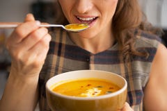 Closeup on woman eating pumpkin soup in kitchen royalty free stock photography Closeup on woman eating pumpkin soup in kitchen royalty free stock photography