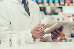 Closeupapotekare Holding Pills Bottle och minnestavla arkivbild Closeupapotekare Holding Pills Bottle och minnestavla arkivbild