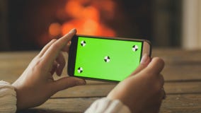 Closeupbild av den hållande smartphonen för ung kvinna och danandebild av den brinnande spisen Tom grön skärm för att sätta in royaltyfri bild Closeupbild av den hållande smartphonen för ung kvinna och danandebild av den brinnande spisen Tom grön skärm för att sätta in royaltyfri bild