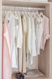 Clothes hanging in wooden wardrobe stock image Clothes hanging in wooden wardrobe stock image