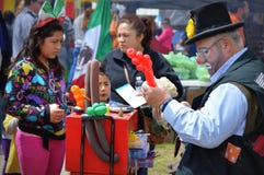 Clown Balloon Artist. A clown balloon artist twists a balloon for a young girl wearing a Mexcian flag bow headband at the Cinco de Mayo festival in Delavan, WI Clown Balloon Artist. A clown balloon artist twists a balloon for a young girl wearing a Mexcian flag bow headband at the Cinco de Mayo festival in Delavan, WI