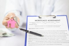 Clé sûre de maison de participation de main de jeune homme, vrai agent immobilier photo stock Clé sûre de maison de participation de main de jeune homme, vrai agent immobilier photo stock