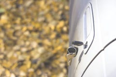 Clés oubliées de voiture dans la porte, un fond d'une forêt trouble d'automne avec un effet de bokeh photographie stock libre de droits Clés oubliées de voiture dans la porte, un fond d'une forêt trouble d'automne avec un effet de bokeh photographie stock libre de droits