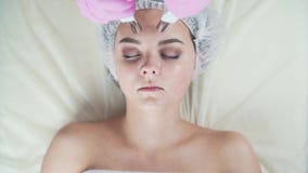 Clínica da beleza Uma mulher obtém a beleza o procedimento facial da cosmetologia vídeos de arquivo Clínica da beleza Uma mulher obtém a beleza o procedimento facial da cosmetologia vídeos de arquivo