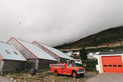 coche de bomberos cerca del garaje y casas de madera hermosas cerca de las montañas en la niebla, Siglufjordur, Islandia imagen de archivo coche de bomberos cerca del garaje y casas de madera hermosas cerca de las montañas en la niebla, Siglufjordur, Islandia imagen de archivo