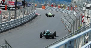 Coches de competición viejos que apresuran a lo largo de la curva Coches de competición viejos que apresuran a lo largo de la curva