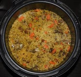 Cocinero del pilaf en un cazo del arroz con el cordero y las verduras Foto de archivo Cocinero del pilaf en un cazo del arroz con el cordero y las verduras Foto de archivo