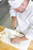 Cocinero profesional que prepara setas en cocina grande fotografía de archivo libre de regalías Cocinero profesional que prepara setas en cocina grande fotografía de archivo libre de regalías
