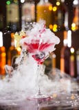 Cocktail con il vapore del ghiaccio ed il liquido di spruzzatura fotografia stock Cocktail con il vapore del ghiaccio ed il liquido di spruzzatura fotografia stock