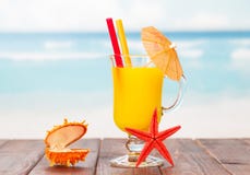 Cocktail, estrela do mar e caixão alaranjados com a pérola no mar azul imagens de stock Cocktail, estrela do mar e caixão alaranjados com a pérola no mar azul imagens de stock