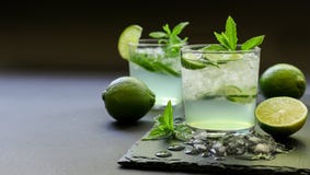 Cocktail frio com licor do limão, cal, tônico, gelo no fundo escuro Imagens de Stock Cocktail frio com licor do limão, cal, tônico, gelo no fundo escuro Imagens de Stock
