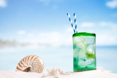 Cocktail with ice, rum, lemon and mint in a glass on beach royalty free stock photography Cocktail with ice, rum, lemon and mint in a glass on beach royalty free stock photography