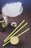 Cocktail making bar tools/Cocktail shaker, lime, ice and straws on a dark background. Top view stock image Cocktail making bar tools/Cocktail shaker, lime, ice and straws on a dark background. Top view stock image