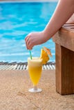 Cocktail, vrouwen` s hand en mening van de pool stock afbeelding Cocktail, vrouwen` s hand en mening van de pool stock afbeelding