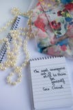 Coco Chanel Quotes Written On A Block Note, Pearl Accessories And An Silky Flower Shirt Royalty Free Stock Photography Coco Chanel Quotes Written On A Block Note, Pearl Accessories And An Silky Flower Shirt Royalty Free Stock Photography