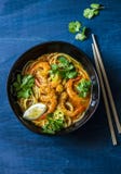 Coconut shrimp laksa soup on a blue background, top view. Copy space. Asian style Royalty Free Stock Photo Coconut shrimp laksa soup on a blue background, top view. Copy space. Asian style Royalty Free Stock Photo