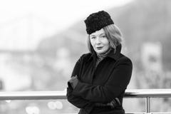 Code vestimentaire d'hiver d'affaires pour chaque jour Femme presque se tenant de la barrière de pont dans le manteau noir Portra images libres de droits Code vestimentaire d'hiver d'affaires pour chaque jour Femme presque se tenant de la barrière de pont dans le manteau noir Portra images libres de droits