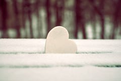 Coeur blanc sur le banc de parc couvert de neige photo stock Coeur blanc sur le banc de parc couvert de neige photo stock