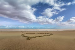 Coeur dans le sable sur une plage image libre de droits Coeur dans le sable sur une plage image libre de droits